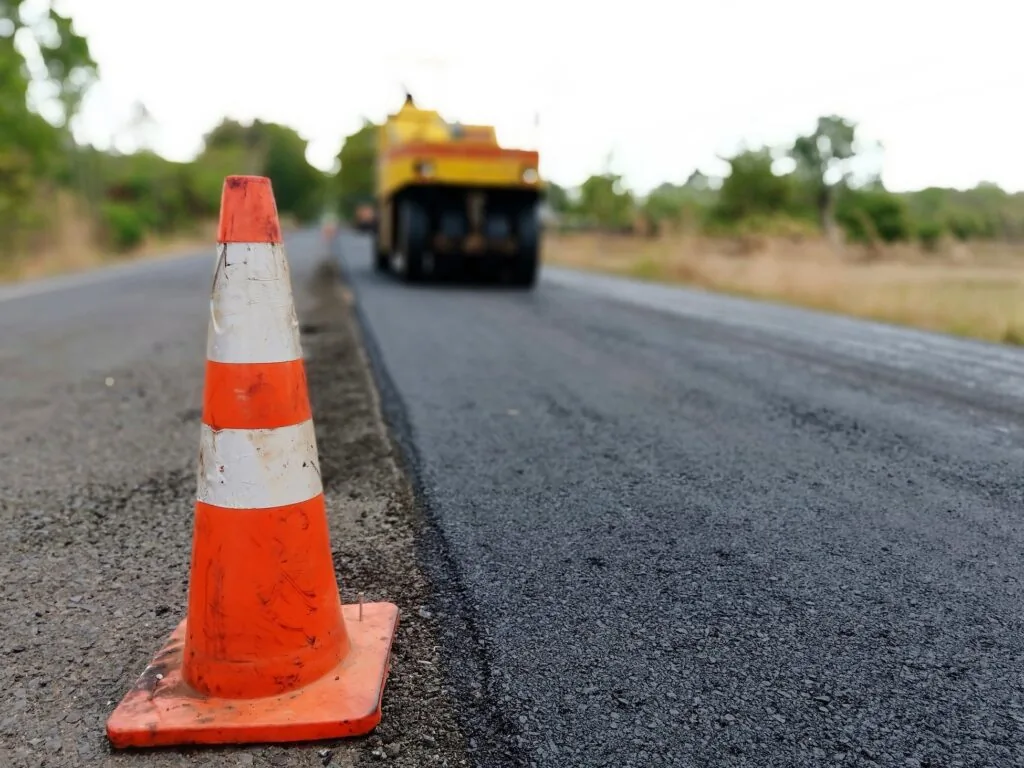 orange traffic cone on the side of the road