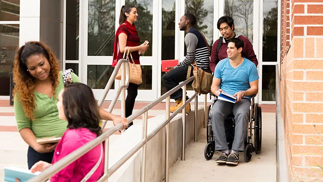man in wheelchair going down a wheelchair ramp