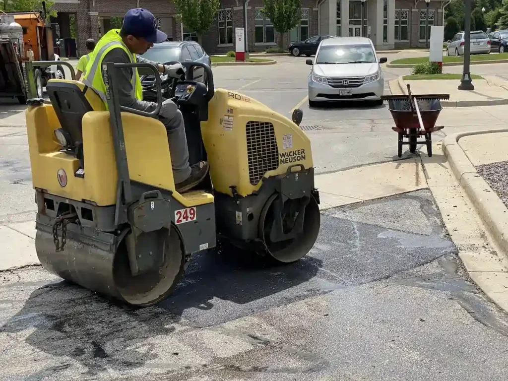 PLM worker performing asphalt repair on a pothole