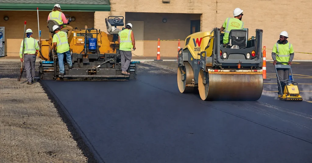 PLM Paving crew performing asphalt overlay in a parking lot