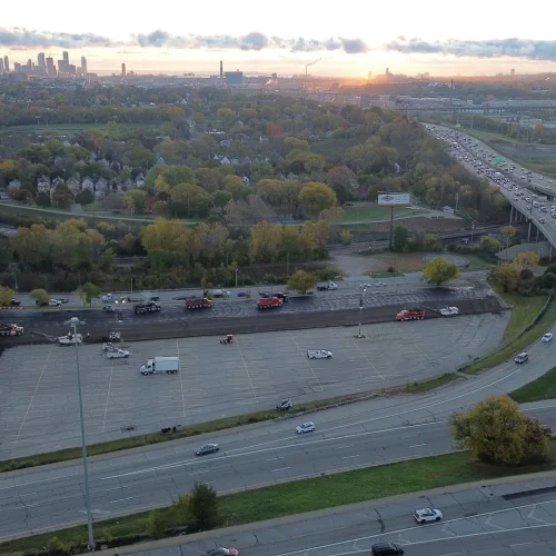 Aerial shot of milling and paving happening at American Family Field parking lot with Milwaukee in the distance.