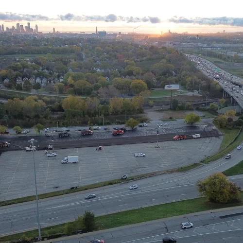 Aerial shot of milling and paving happening at American Family Field parking lot with Milwaukee in the distance.