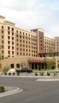 front of a beige hotel