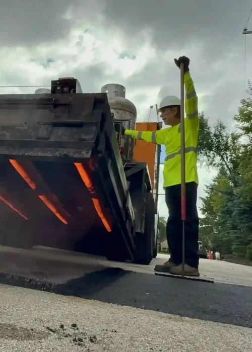 PLM worker using an asphalt patching machine