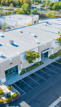 industrial aerial view of a commercial building and parking lot