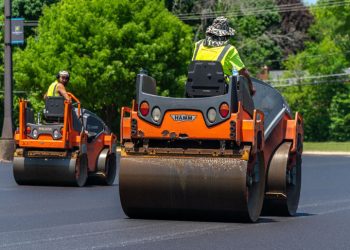 two plm paving employees on asphalt rollers