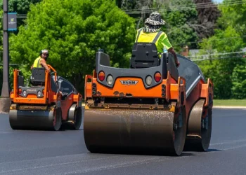 two plm paving employees on asphalt rollers