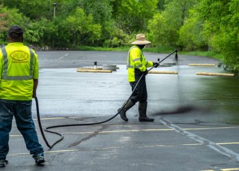plm paving employees sealcoating a parking lot